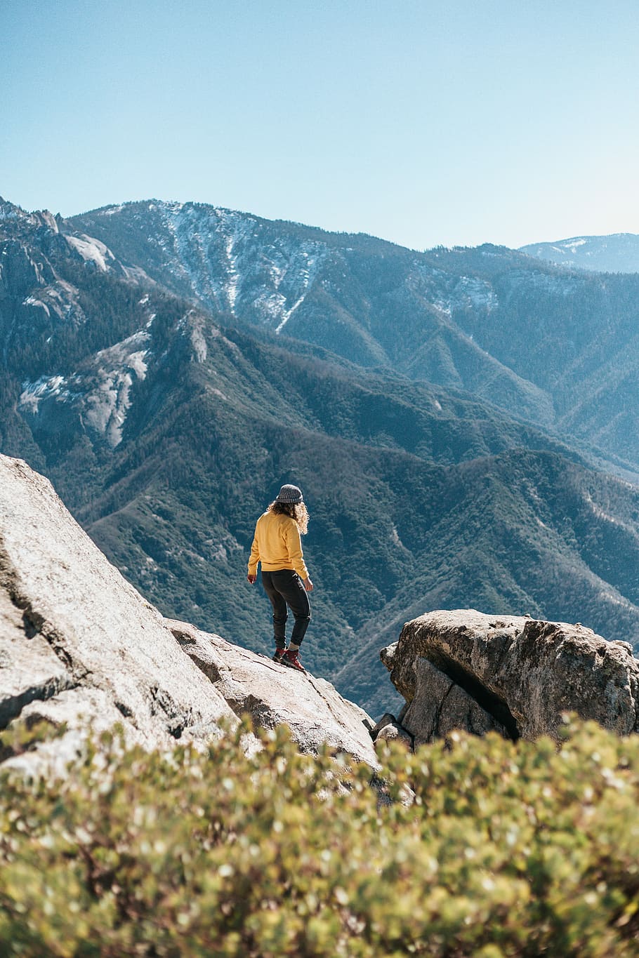 a woman standing on the edge of a cliff, woman standing on gray mountain HD wallpaper