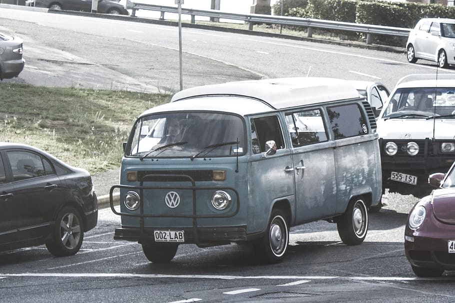 selective closeup photography of blue Volkswagen T1 van on road with other vehicles during daytime