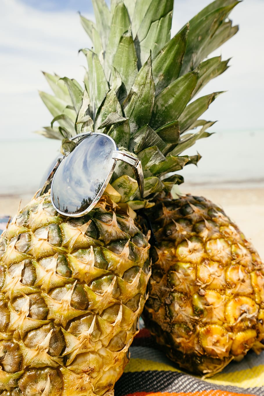gray sunglasses on two pineapple fruits, pineapples, sand, beach HD wallpaper