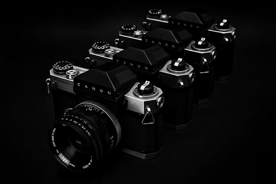 grayscale photo of four point-and-shoot cameras, canon, lens