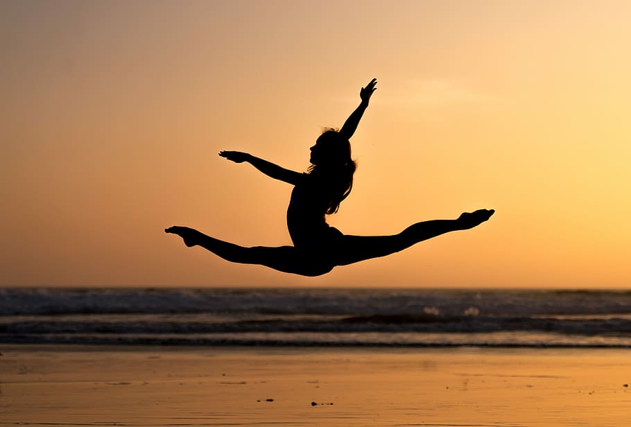 Public Domain. dancer jumping at sunset on the beach, silhouette photo of w...
