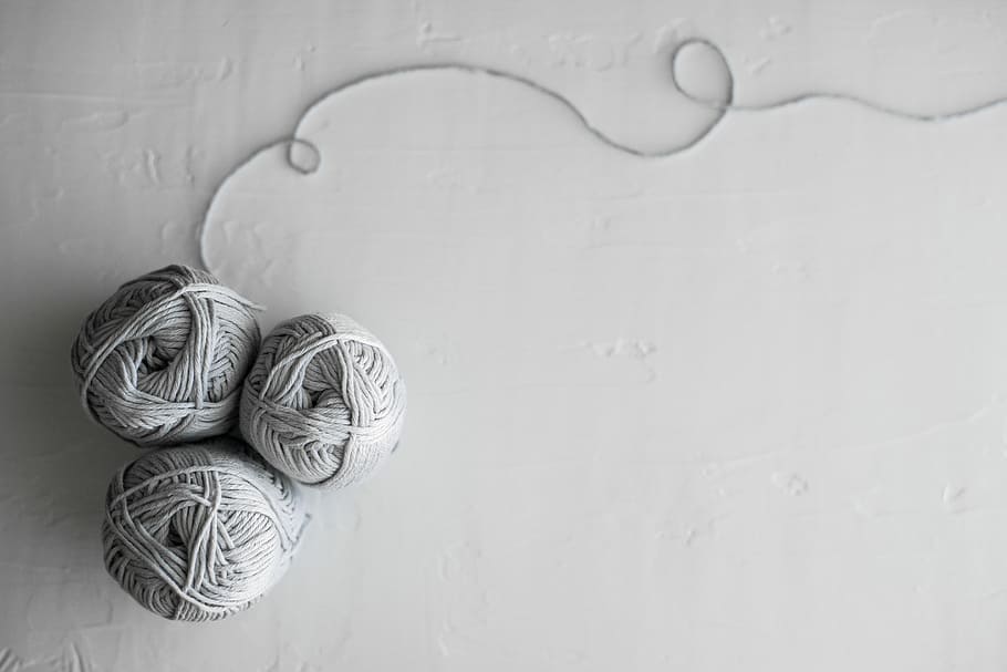 flat lay photography of three white yarn balls, grayscale photo of yarns