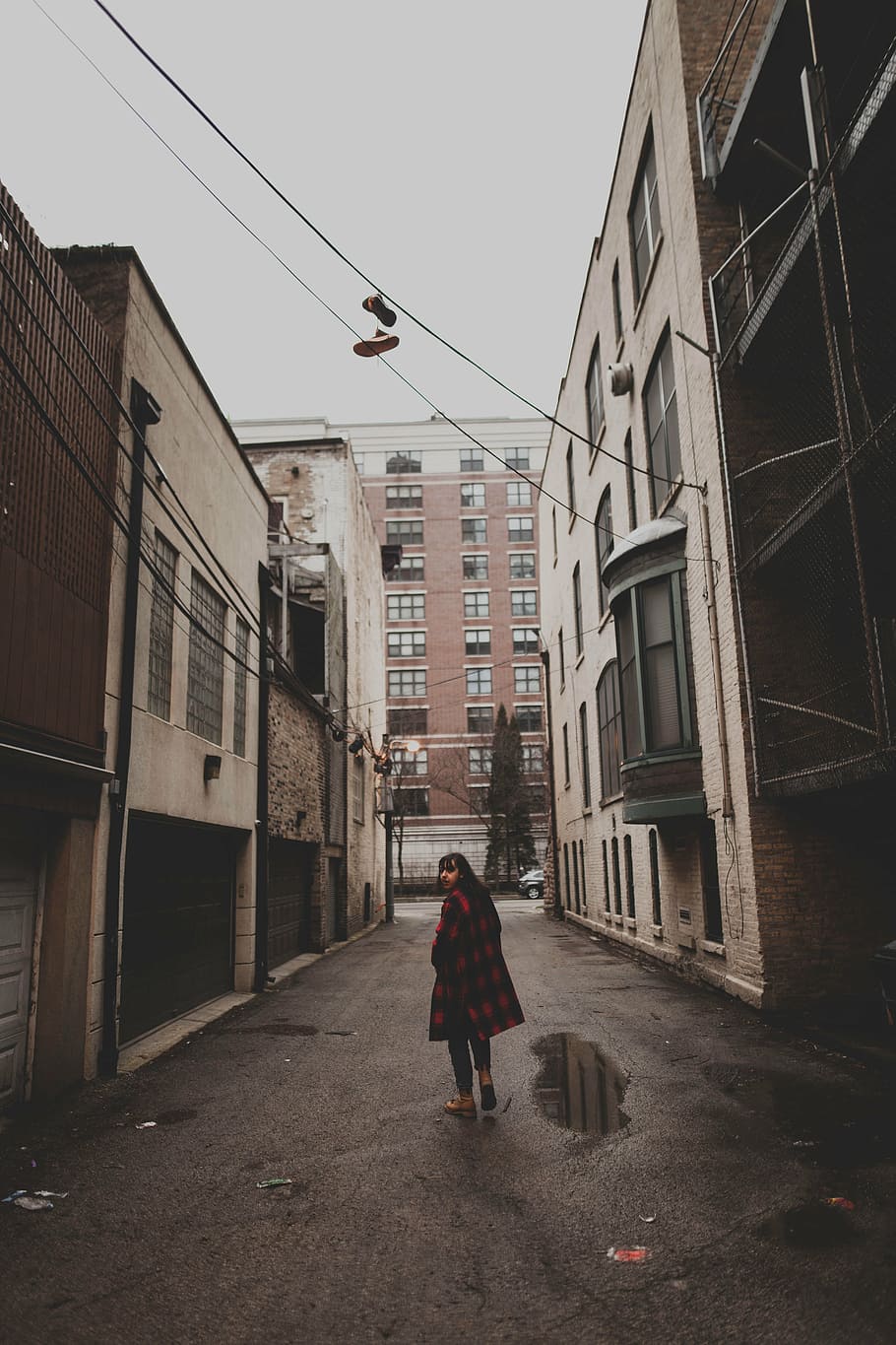 woman standing in the middle of narrow road between buildings