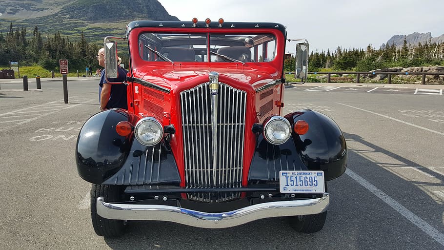 parked red and black vehicle during daytime, glacier national park