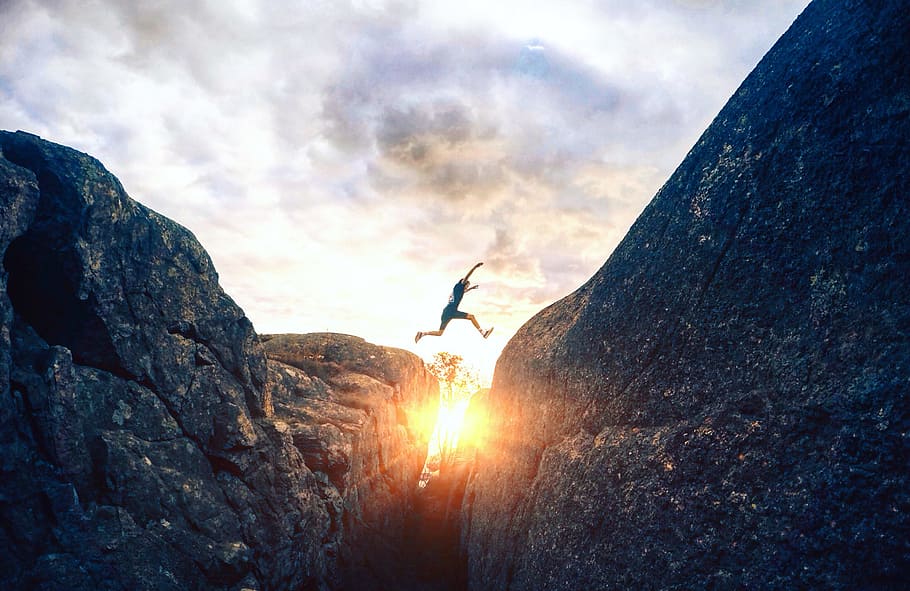 person leap on another hill during sunset, jump, rock, crevasse