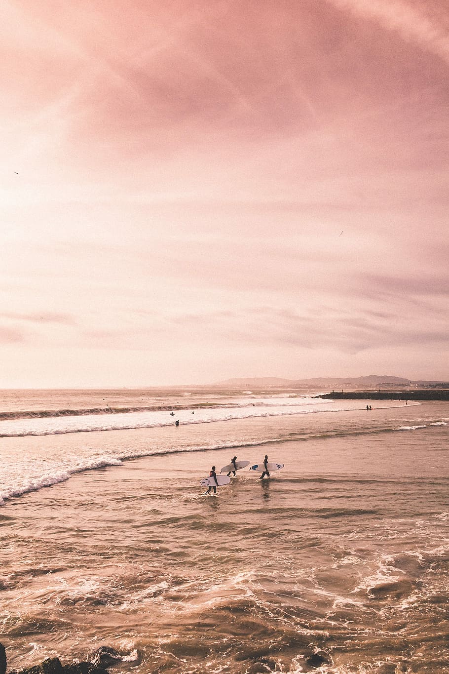 several people standing on seashore, three man carrying white surfboard on seashore open sea under cloudy sky during daytime HD wallpaper