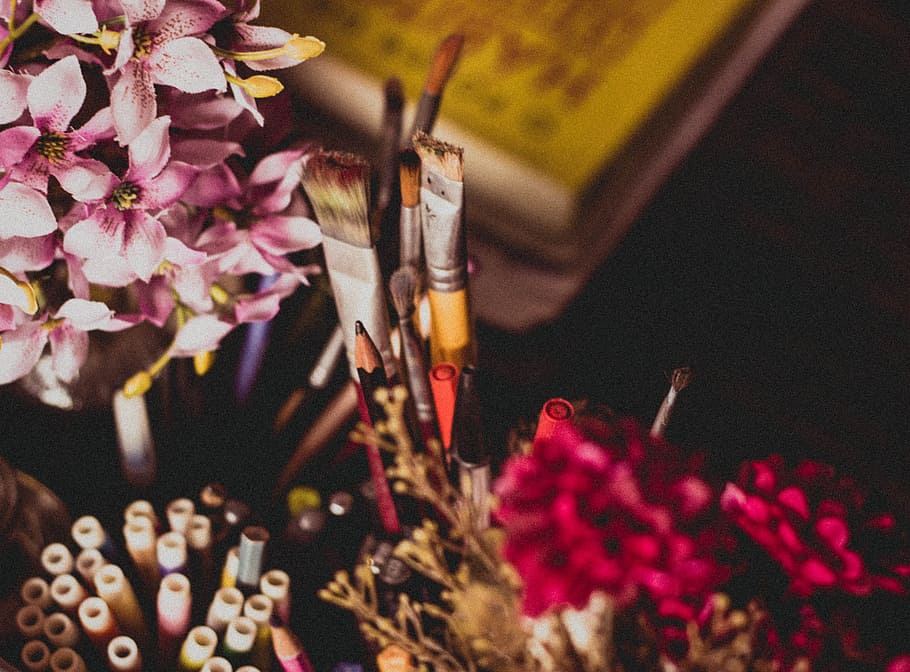 selective focus photography of makeup brush and pencil and pens beside pink and purple flowers, selective-focus photo of paintbrushes, HD wallpaper