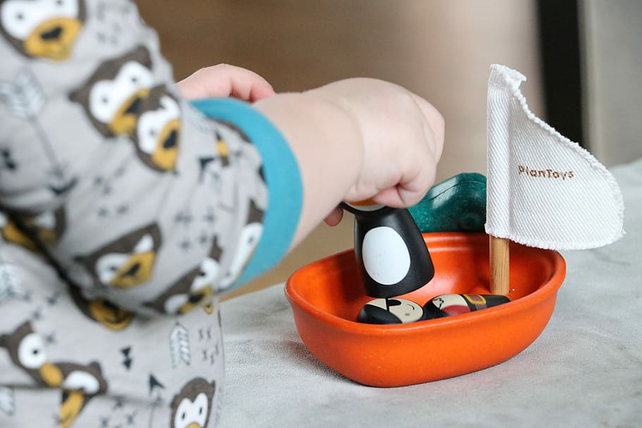 toddler's playing orange sail boat toy, toys, plan toy, human hand HD wallpaper