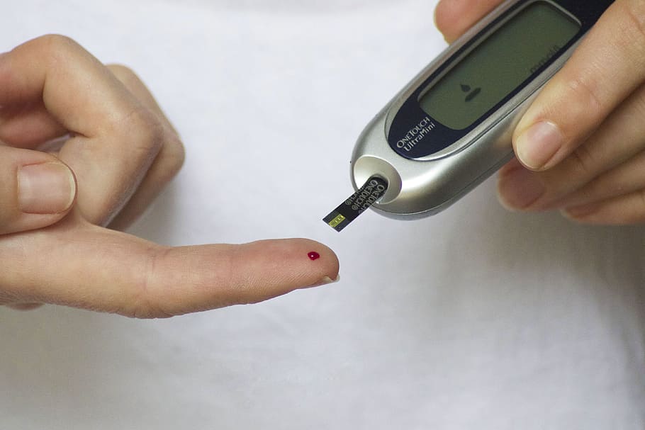 person taking blood on glocumeter, glucometer, diabetes, finger