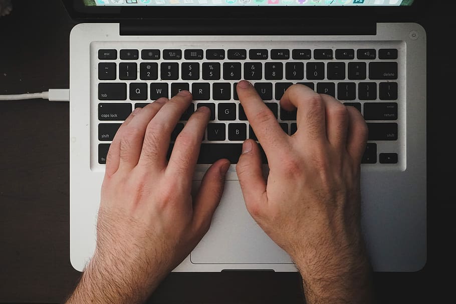 person using MacBook, person's hand on MacBook Pro, typing, keyboard HD wallpaper
