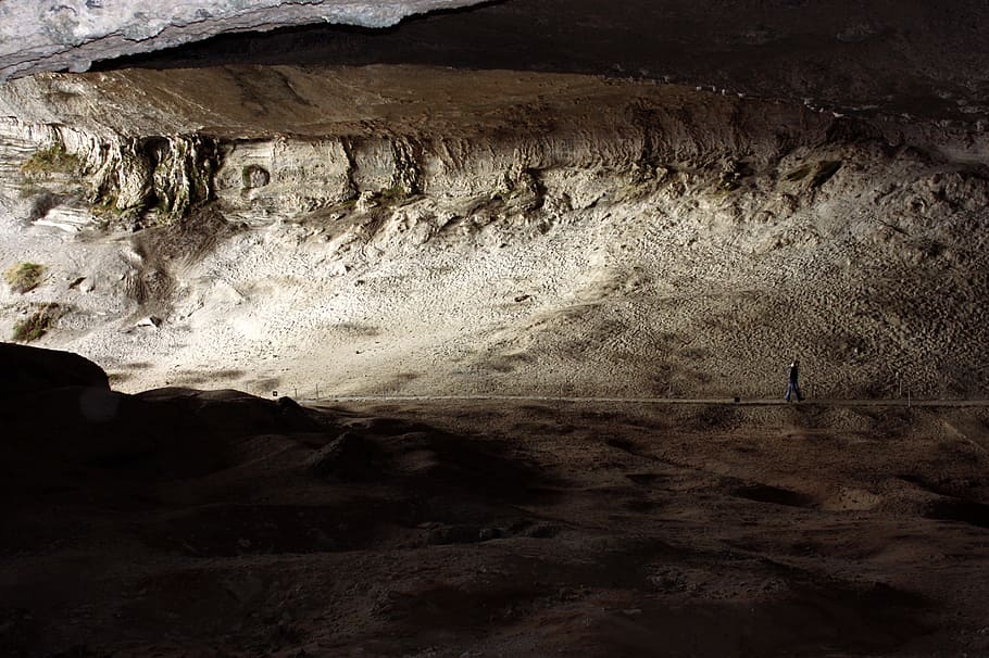 person walking inside cave with sun lights, person walking in cave HD wallpaper