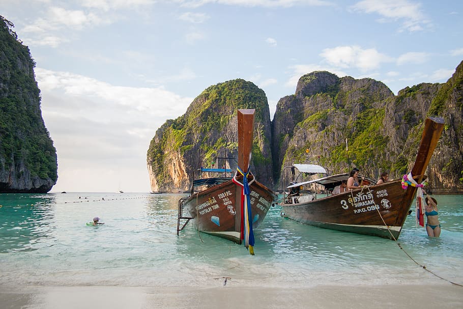 two brown boat near beach rock formation, thailand, the beach