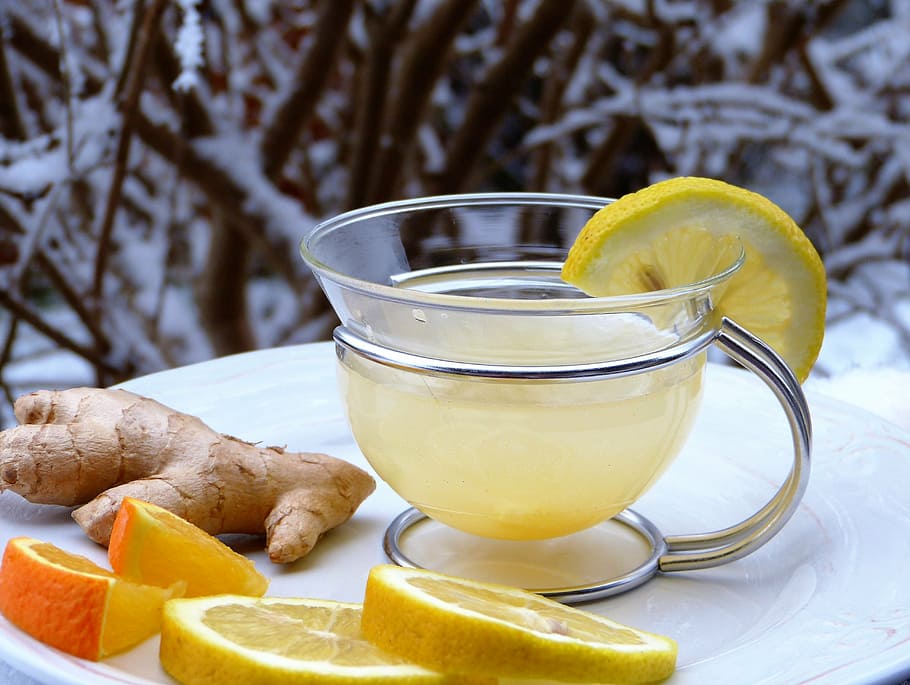 lemon juice filled clear glass mug, ginger, orange, snow, hot