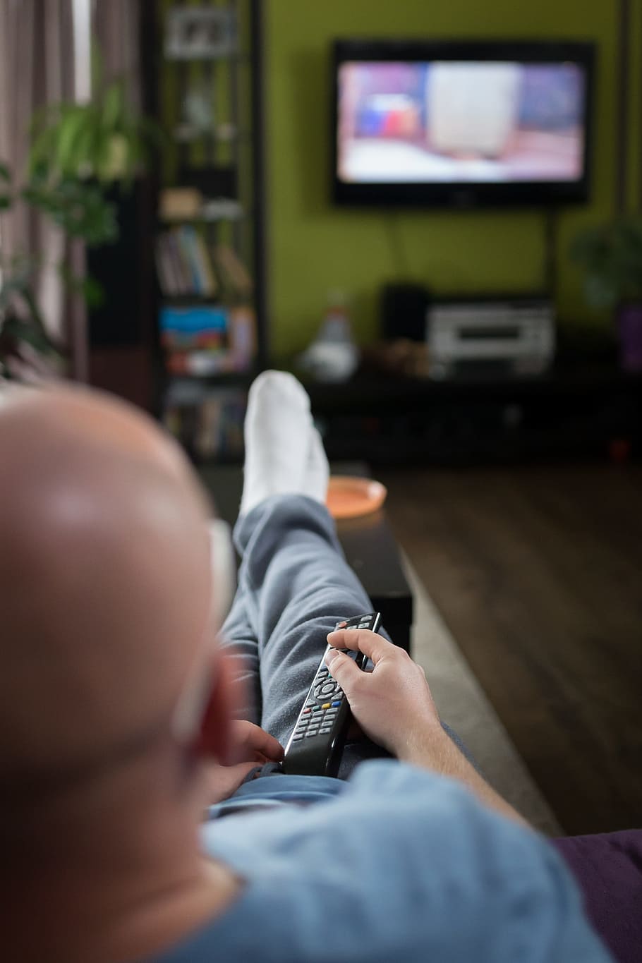 man watching television using remote control, television and radio