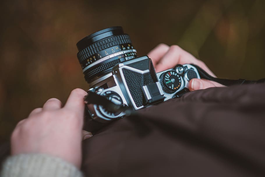 selective focus photography of person carrying camera, person holding gray and black DSLR camera HD wallpaper