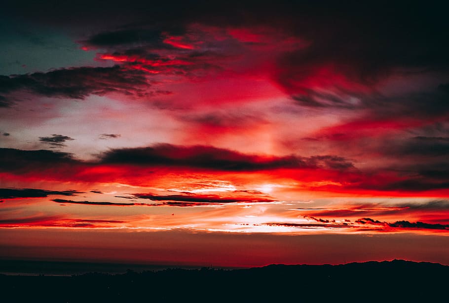 silhouette of mountain under cloudy sky during golden hour HD wallpaper