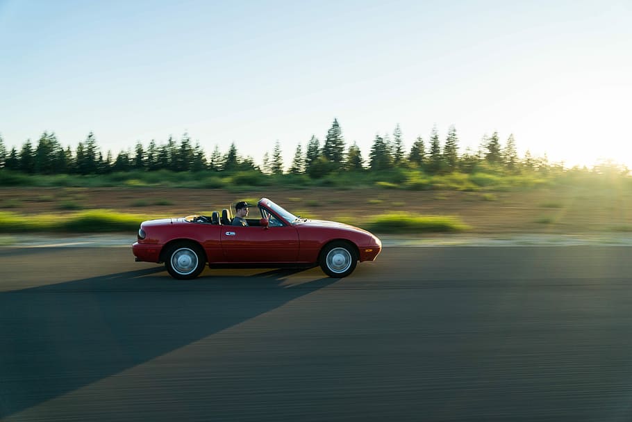person driving red convertible coupe running on concrete road HD wallpaper
