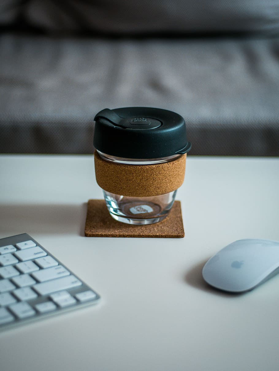 covered jar between Magic Mouse and Keyboard on desk, selective focus shot of clear glass tumbler between Apple Magic keyboard and Mighty mouse HD wallpaper