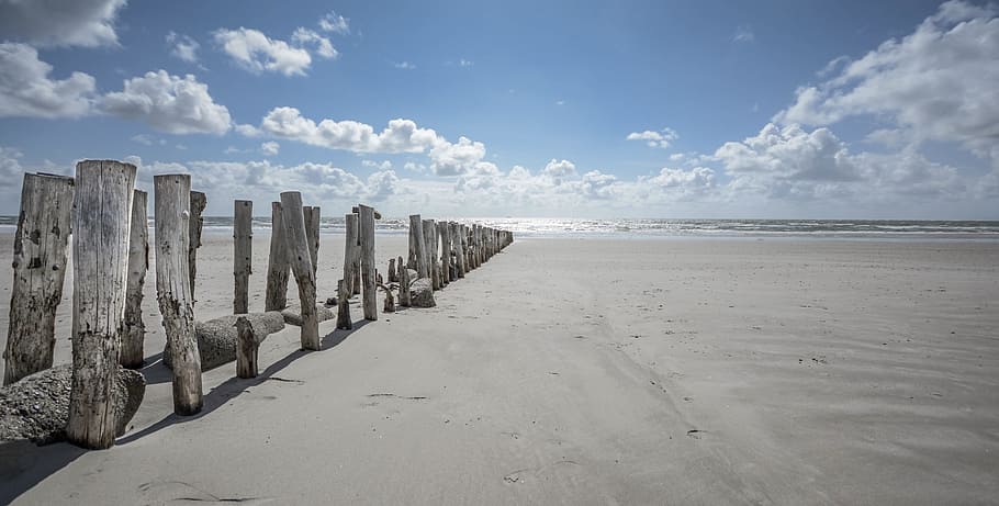 photo of seashore, beach, sand, wood, posts, blue, sky, clouds HD wallpaper
