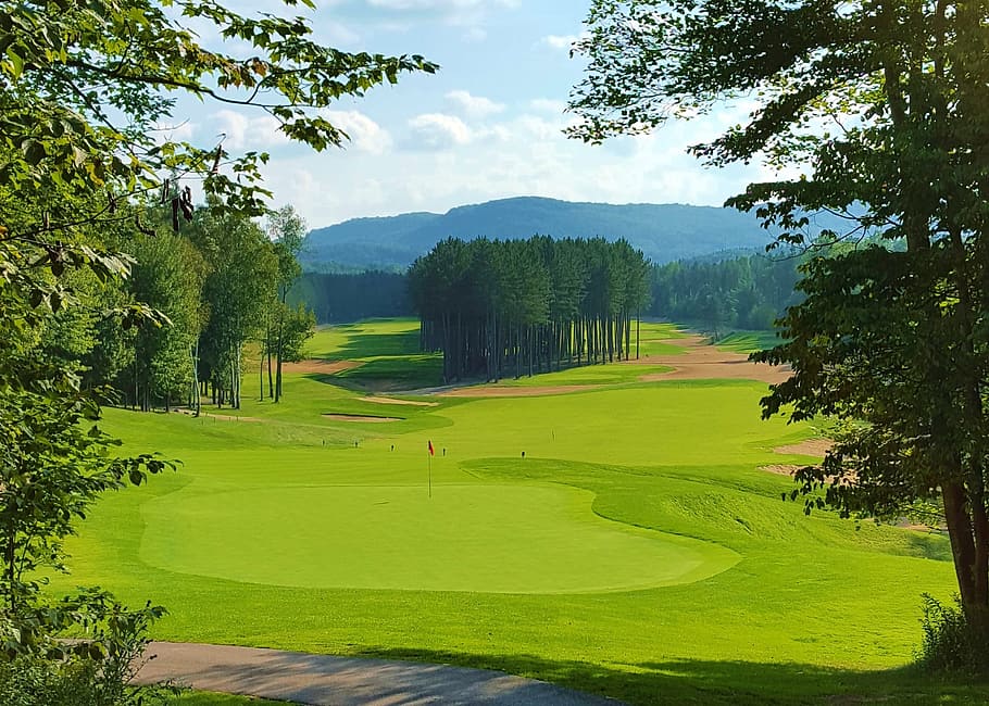 landscape photo of green golf field under cloudy sky during daytime HD wallpaper