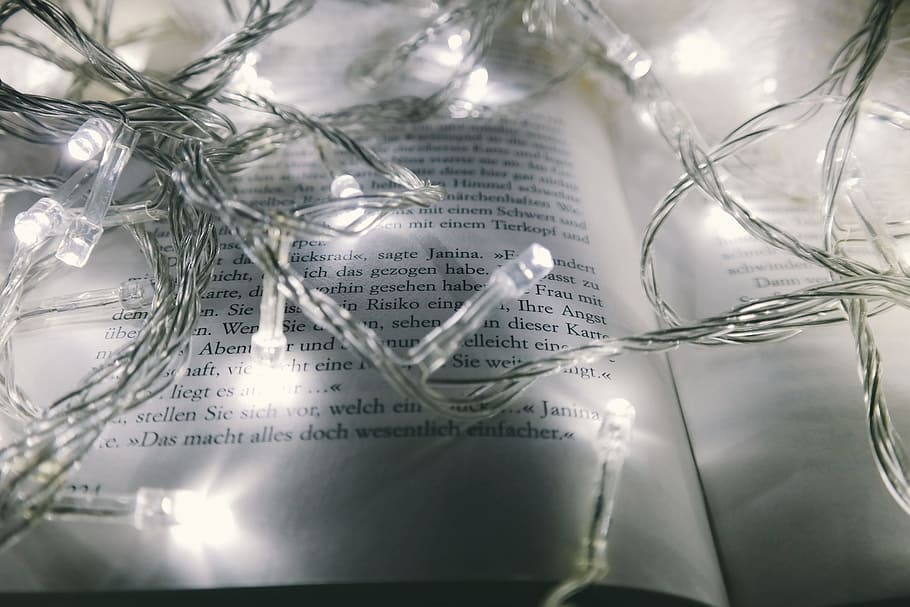 photography of turned on white string lights on opened book page HD wallpaper