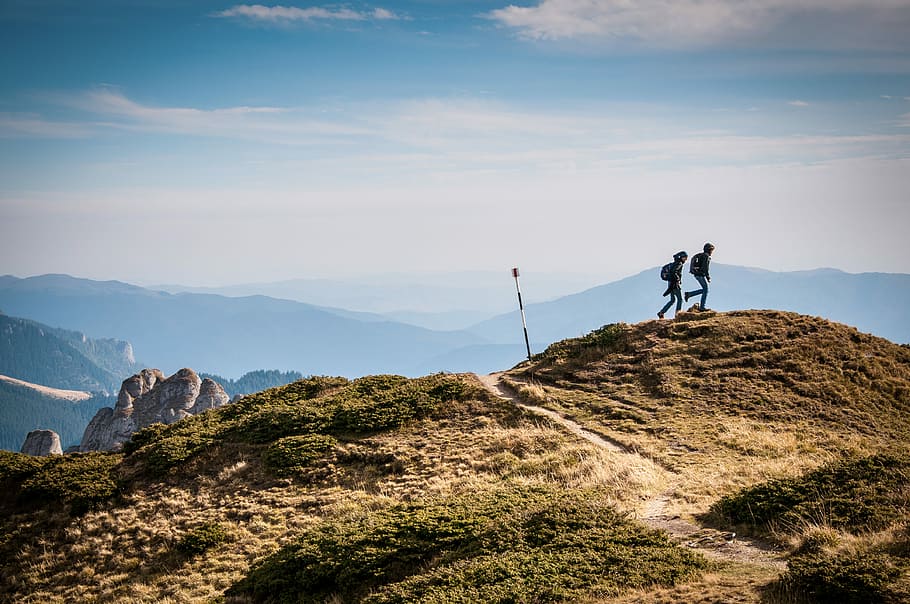 silhouette of two person on hill, photography of two person walking at mountain top HD wallpaper