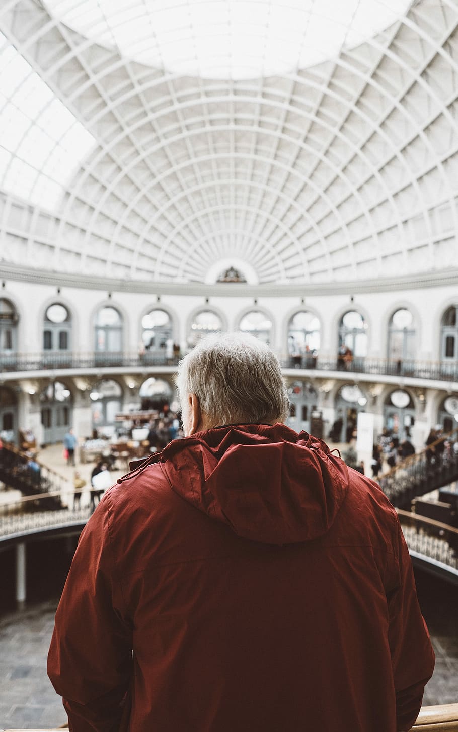 man wearing red hoodie inside dome building in front of people, man in red jacket looking down at the house HD wallpaper