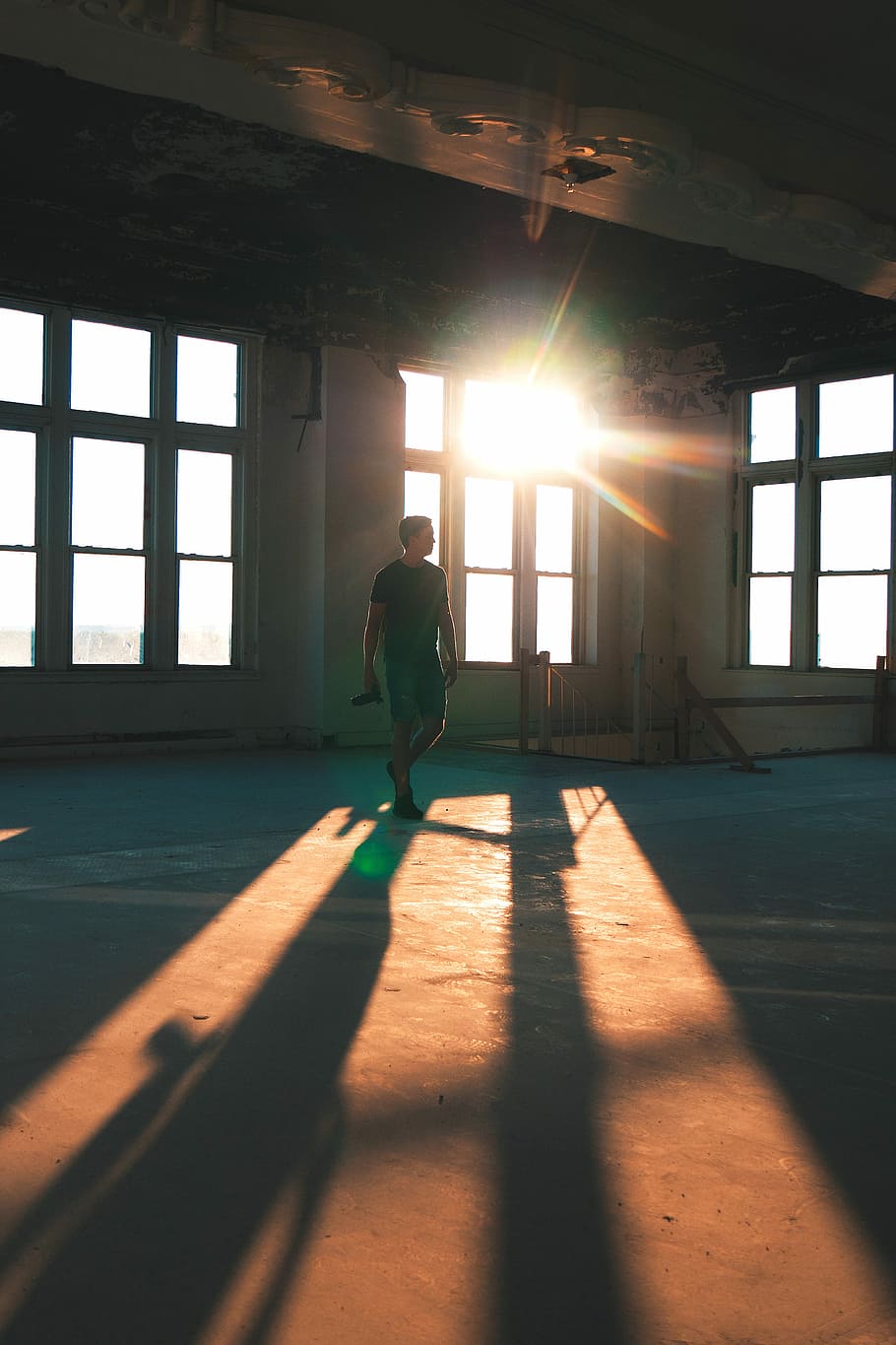 man standing near stairs and windows during daytime, man standing on brown concrete floor HD wallpaper