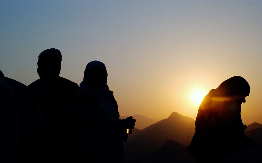 silhouette photo of people standing near mountains during sunset HD wallpaper