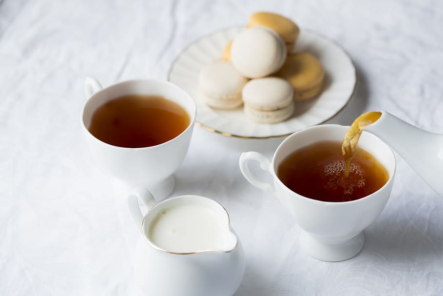 two cups of coffee beside the macaroons on plate, two white ceramic tea cups and white teapot HD wallpaper