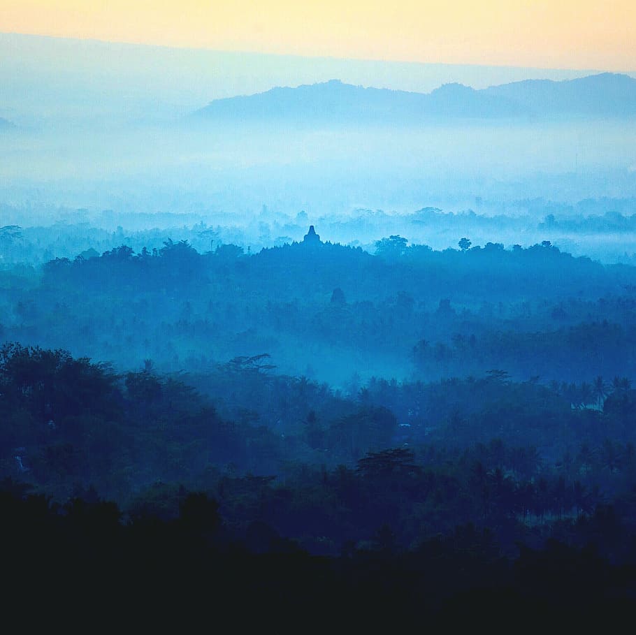 landscape photography of mountain range, foggy, town, daytime HD wallpaper
