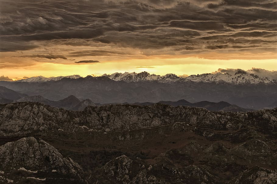 mountain under cloudy sky during sunset, silhouette photo of mountain ranges during golden hour HD wallpaper
