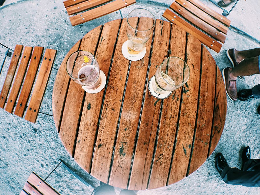 Parkin en la rana, three clear glass beer pints on brown wooden table with chairs HD wallpaper
