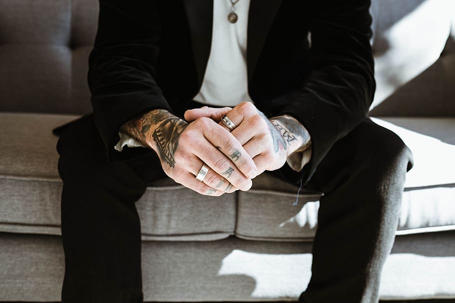 person's wearing silver-colored ring while sitting on couch HD wallpaper