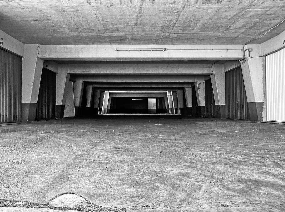 grayscale photography of empty warehouse, underground car park