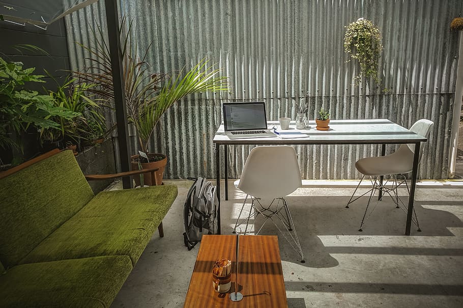 laptop computer on top of table, MacBook Pro on white table beside green padded sofa HD wallpaper