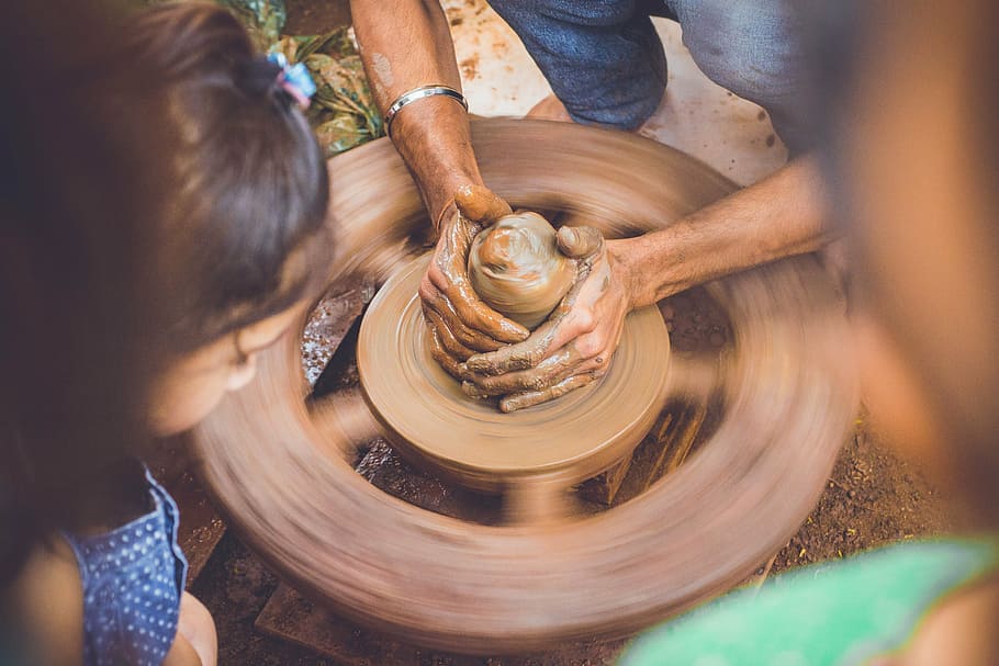 person making clay pot during daytime, hands, slow motion, brown