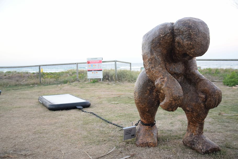 brown concrete statue, Cellphone, Slave, Shackles, outdoors HD wallpaper