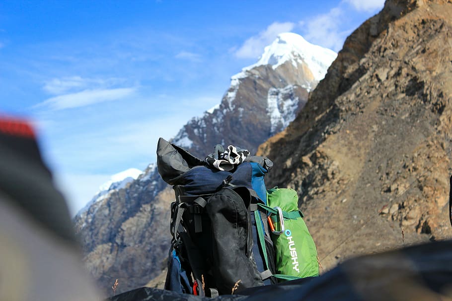 black and green travel backpack near mountain at daytime, snow-cap mountain during daytime HD wallpaper