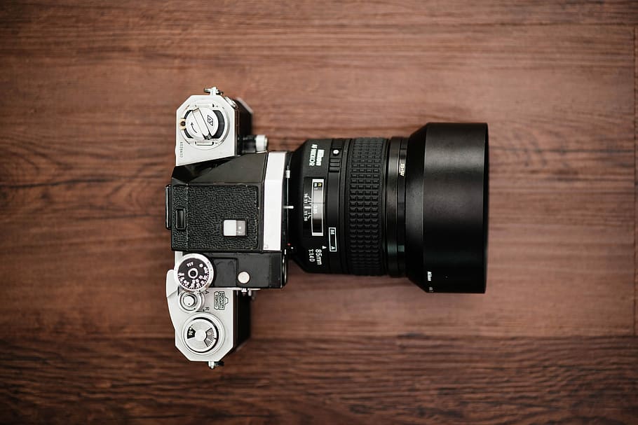 black and gray DSLR camera on brown surface, black and silver DSLR camera on top of brown wooden table HD wallpaper