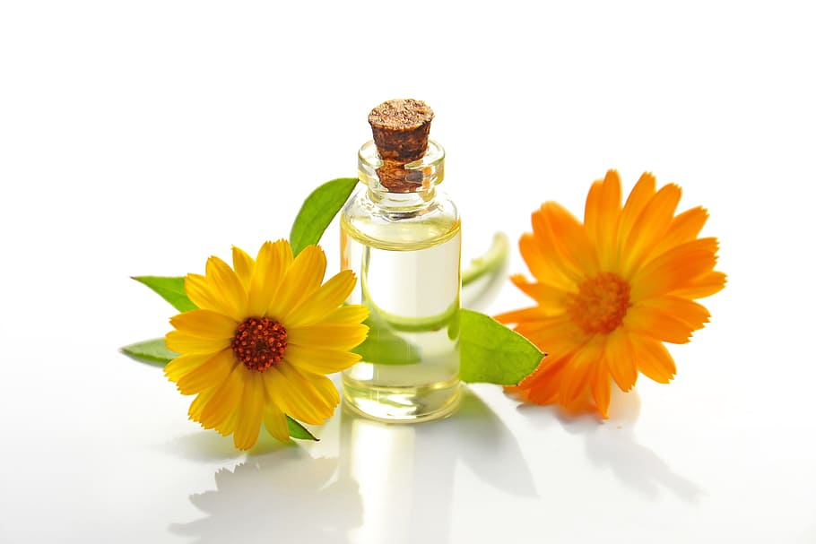 clear glass jar between yellow and orange petaled flowers, essential oil, HD wallpaper
