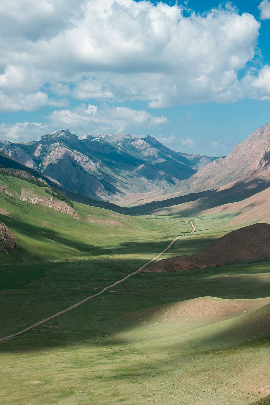 green grass field valley under white clouds during daytime, mountain and road HD wallpaper