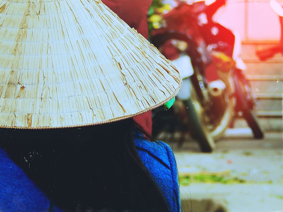 person wearing rice hat facing white motorcycle parked beside red wall, person wearing round native hat HD wallpaper