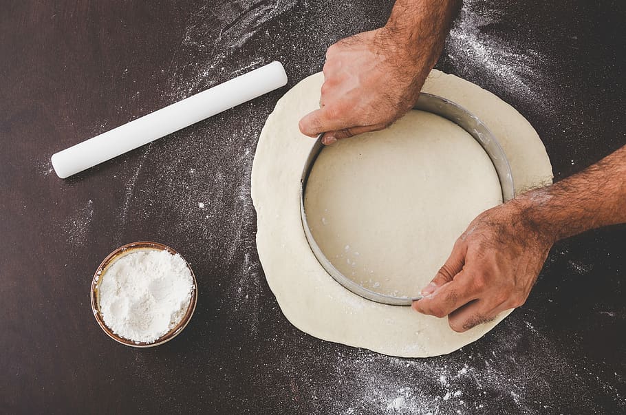 person cutting dough with round cutter, person holding round cookie cutter on white dough HD wallpaper