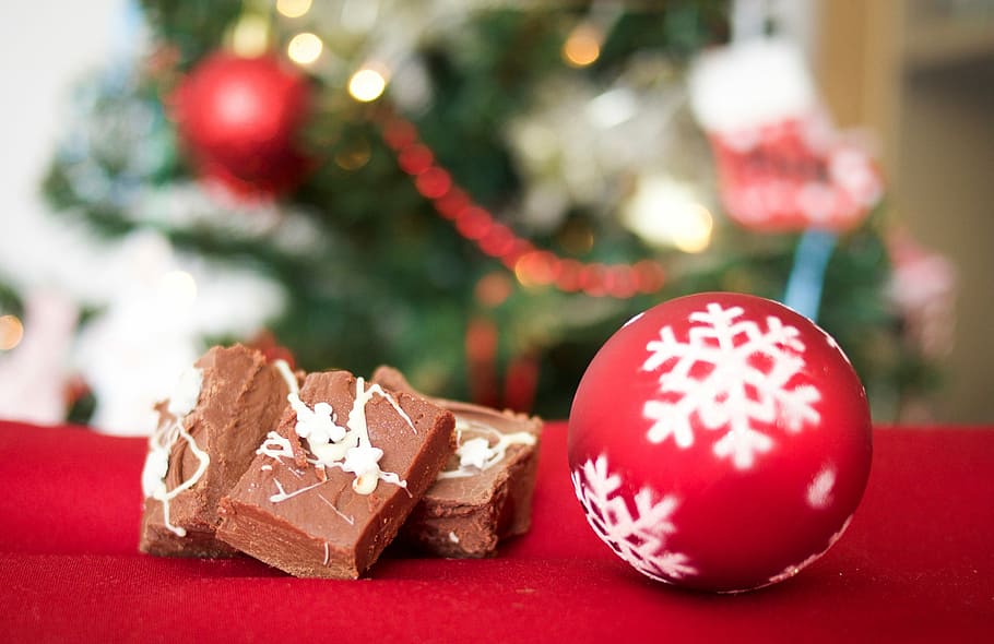 Christmas cookies, red and white baubles beside chocolate on red surface HD wallpaper