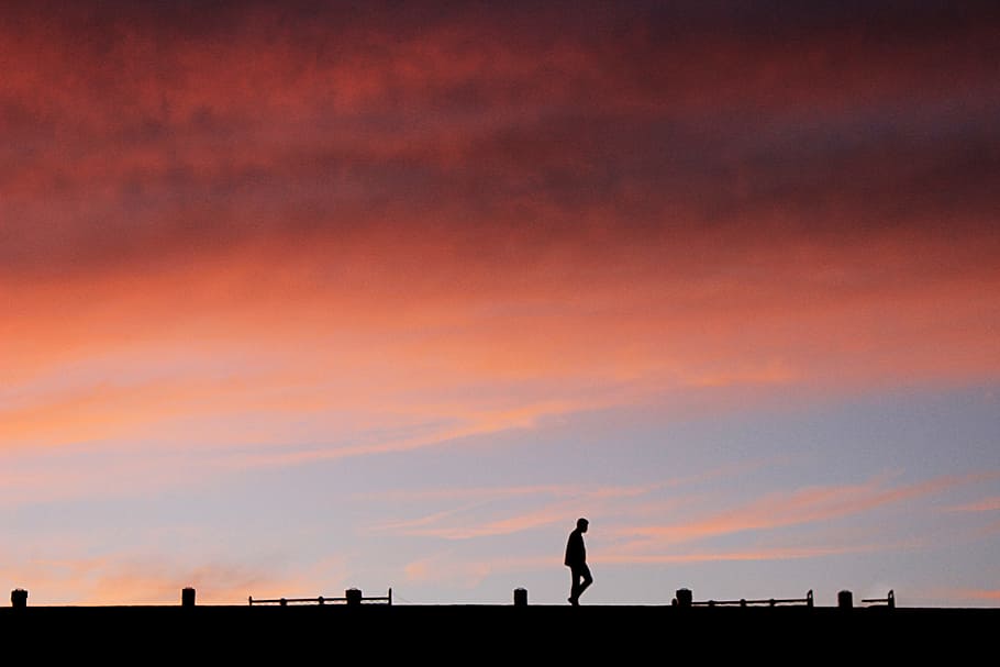 silhouette of man at golden hour, silhouette of man walks on bride during orange clouds HD wallpaper
