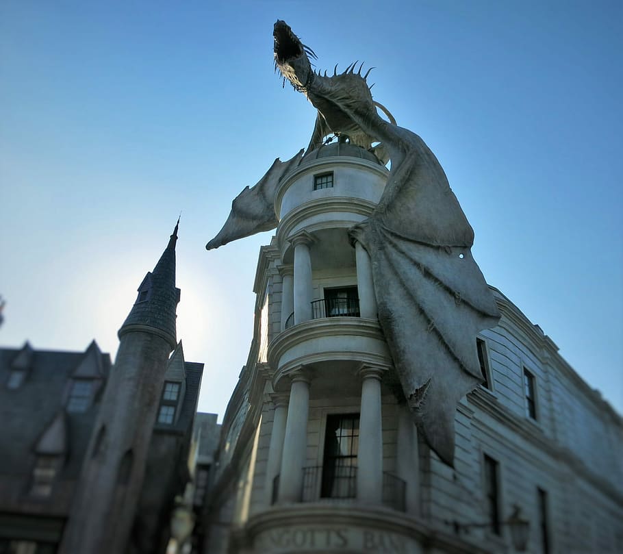 brown dragon sculpture on white 3-storey building over blue sky at daytime