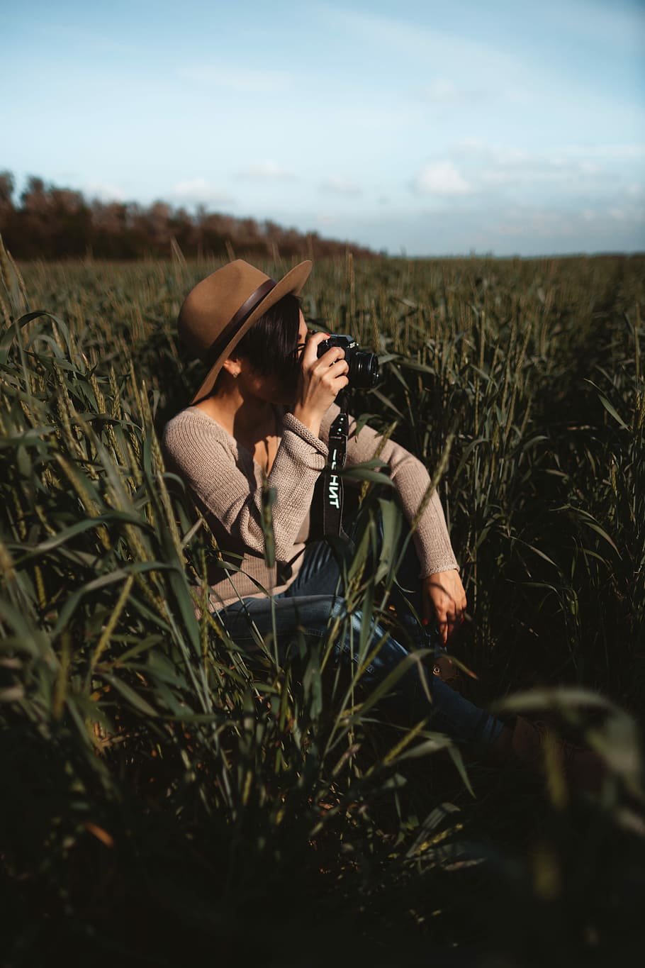woman taking photo while sitting on green grass field, woman sitting on grass field while talking photo using DSLR camera HD wallpaper