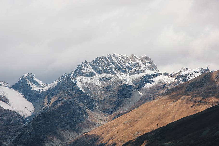 white and brown mountains under cloudy sky at daytime, aerial photography of snow-capped mountains HD wallpaper