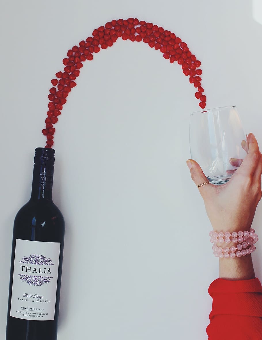Thalia wine bottle beside clear beverage glass, flowing, wine glass
